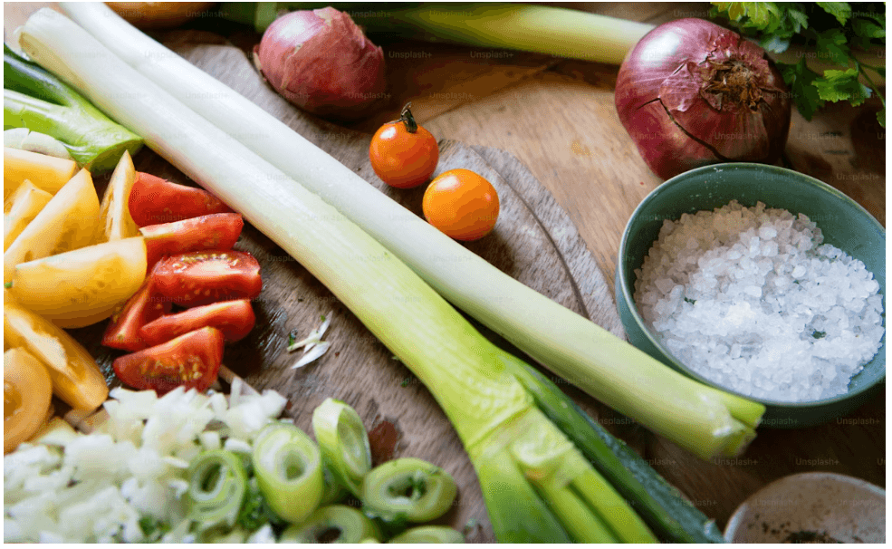 Fresh onions on a dark surface — heritage cooking ingredients